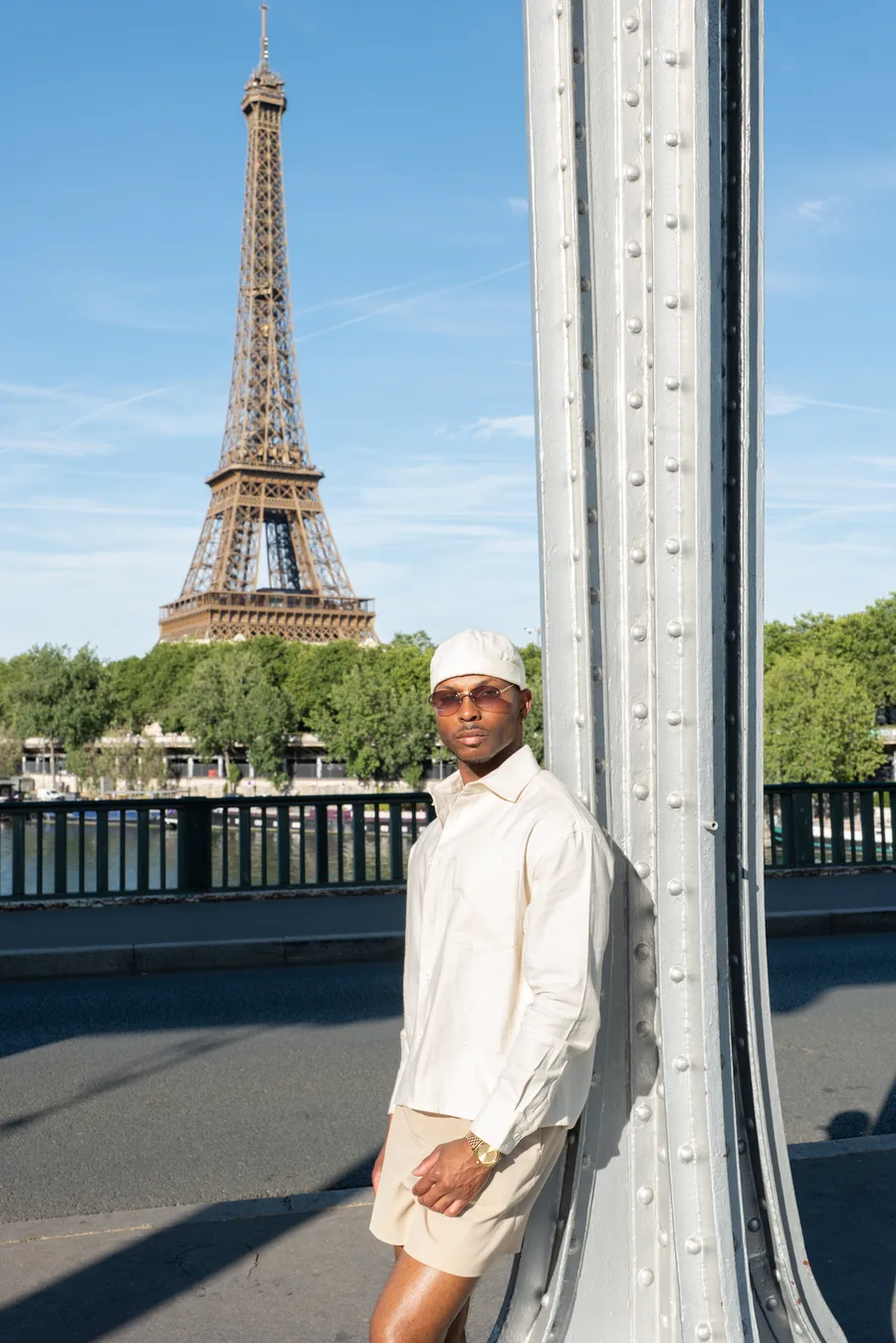 Solo traveller posing beside the Eiffel Tower on a Paris bridge