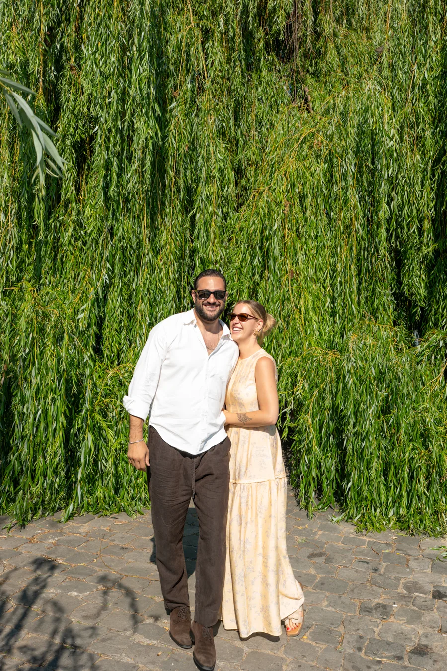 Couple photographed in front of leafy greenery in Paris