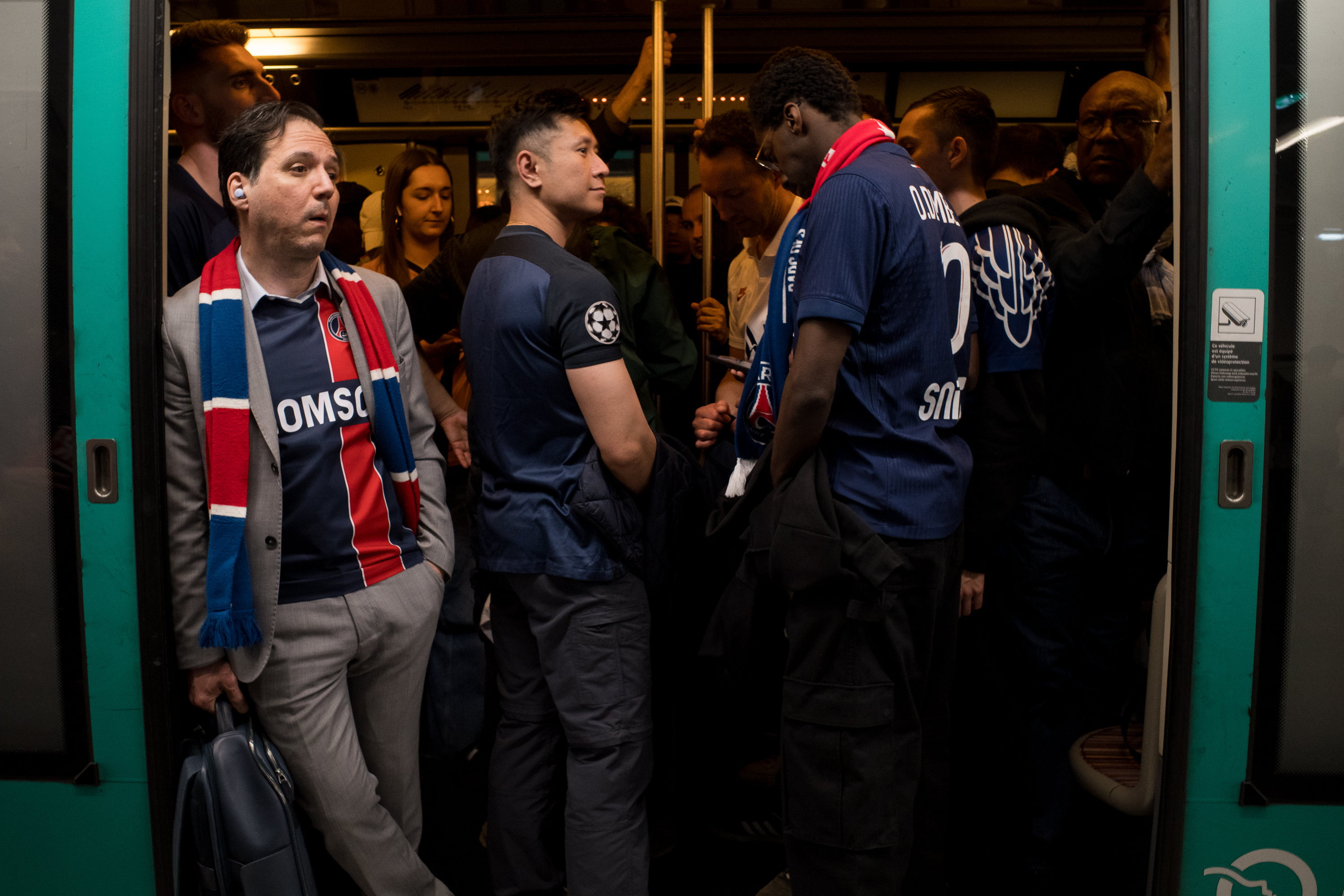 PSG supporters packed into the doorway of a Paris Métro carriage after a match