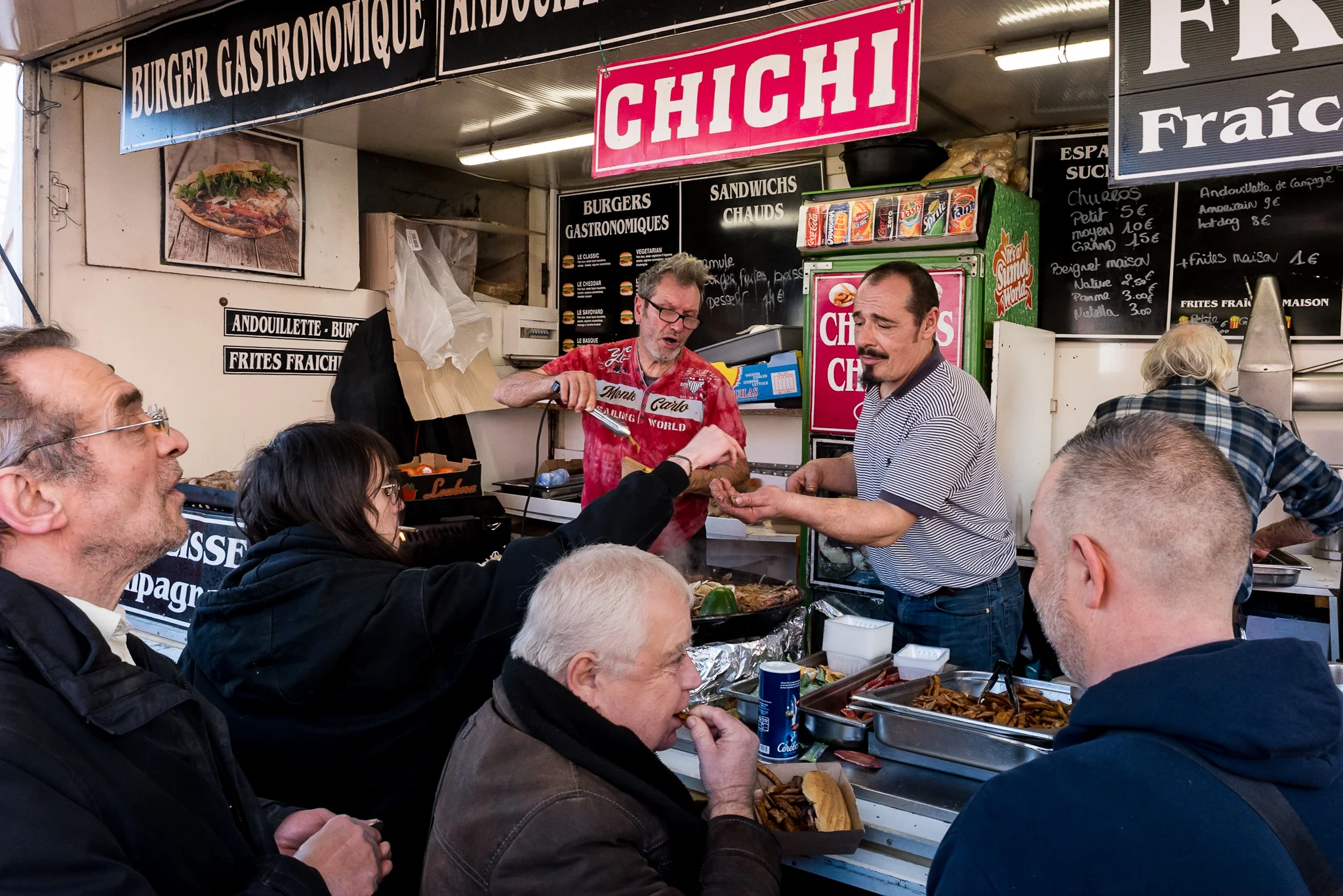Customers gathered around the Chichi street food counter in Paris &mdash; photograph by Dan Umareta